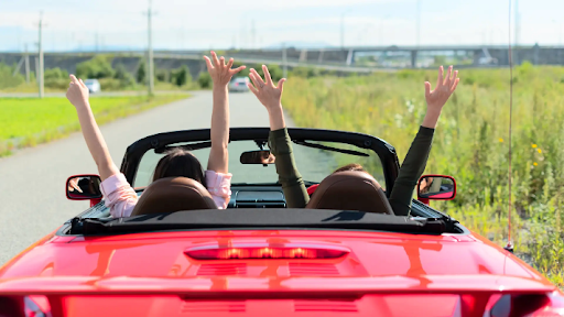 Trade in old car – Women in a convertible driving down the road